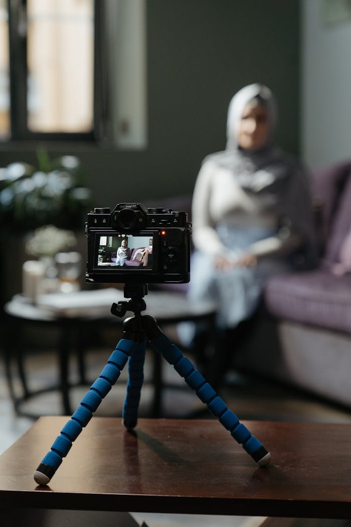 services-02 Camera on a tripod filming a woman in a cozy living room setting for a vlog.
